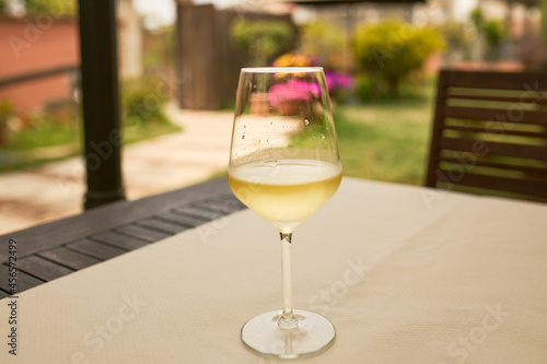 Glass of white wine on a table on a terrace. © MiguelAngel