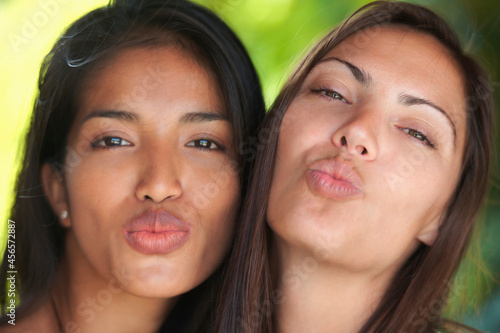 Close up portrait of two woman friends puckering lips