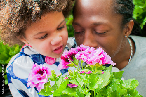 Canvas Print Close up of father and daughter smelling flowers in garden