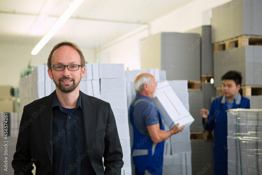 Obraz premium Factory workers moving and stacking cardboard