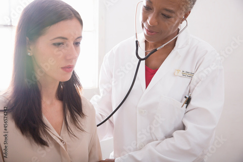 Female doctor using stethoscope during check up