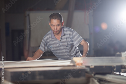 Obraz na płótnie Carpenter working on wood plank in factory, Jiangsu, China
