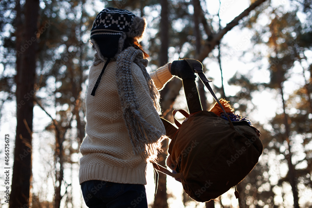 Fotografie Mature female backpacker lifting up backpack in forest