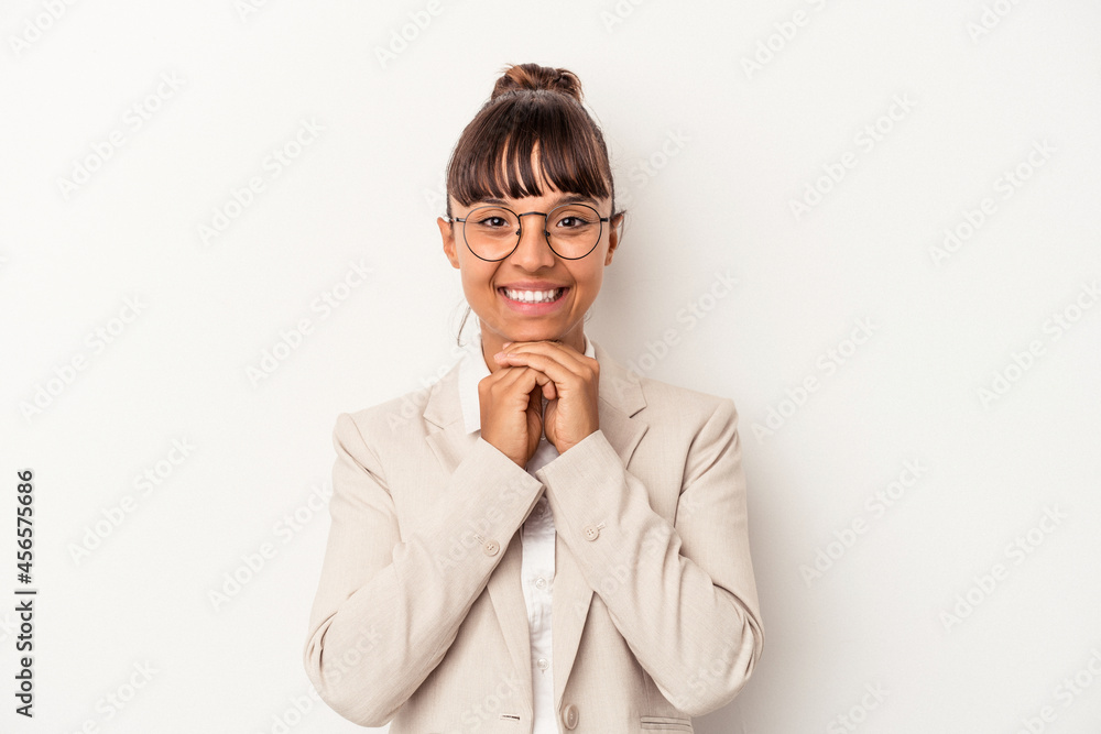 Young mixed race woman isolated on white background keeps hands under chin, is looking happily aside. Young mixed race woman isolated on white background keeps hands under chin, is looking happily aside.
