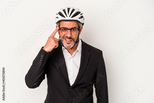Middle age business man wearing a bike helmet isolated on blue background  showing a disappointment gesture with forefinger. © Asier