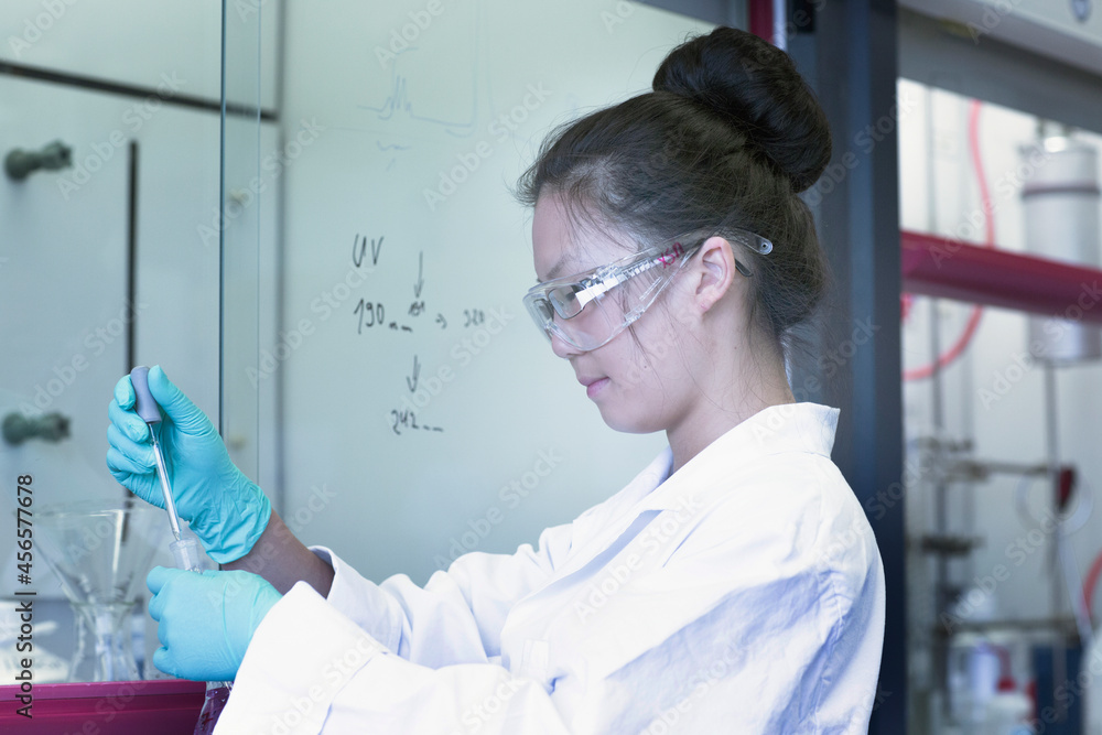 Female scientist in lab pipetting sample Female scientist in lab pipetting sample