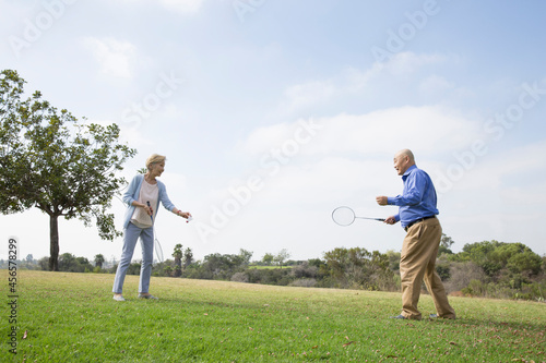 Senior couple playing badminton in park