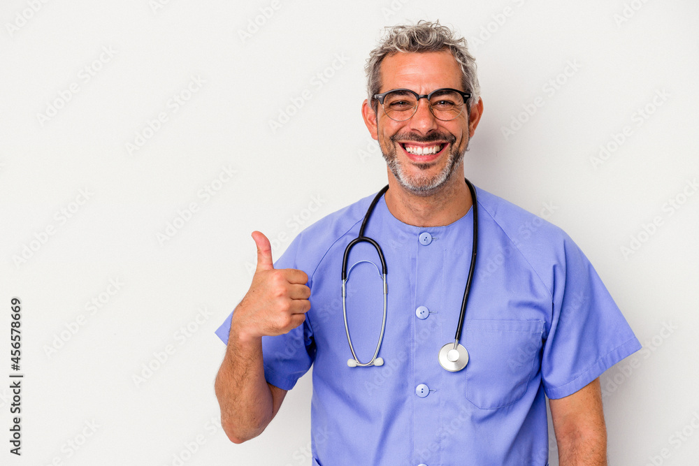 Middle age nurse caucasian man isolated on white background smiling and raising thumb up Middle age nurse caucasian man isolated on white background smiling and raising thumb up