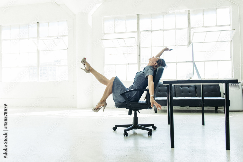 Fototapeta premium Businesswoman excited on chair by office window