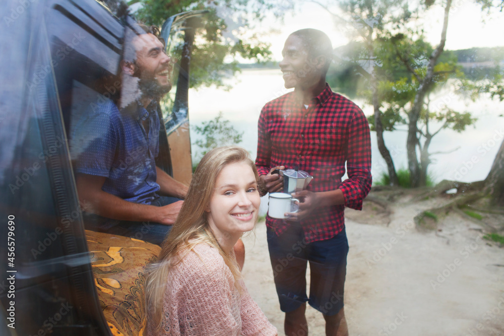 Naklejka premium Friends chatting beside van by lake