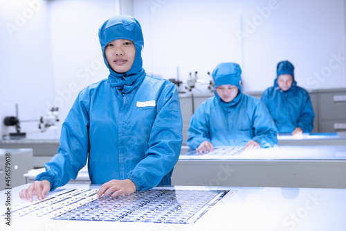 Canvas Print Portrait of female factory worker in flexible electronics factory clean room
