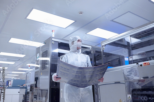 Obraz na plátně Female worker holding flex circuit in flexible electronics factory clean room