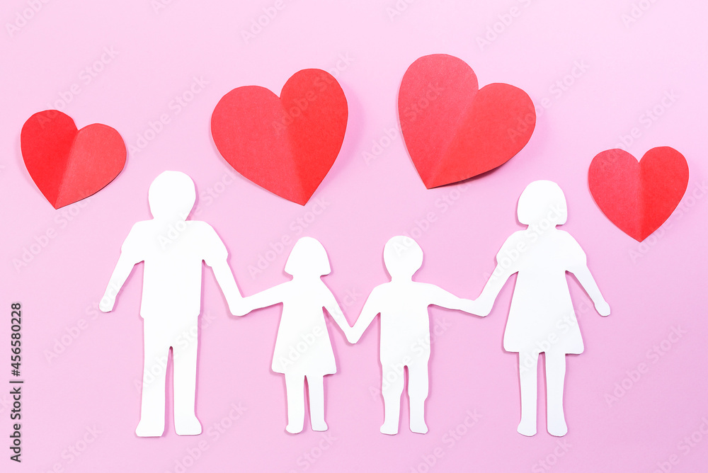 Paper family cut out on bright pink background with paper hearts. Family home, foster care, family mental health, divorce and family crisis concept Paper family cut out on bright pink background with paper hearts. Family home, foster care, family mental health, divorce and family crisis concept