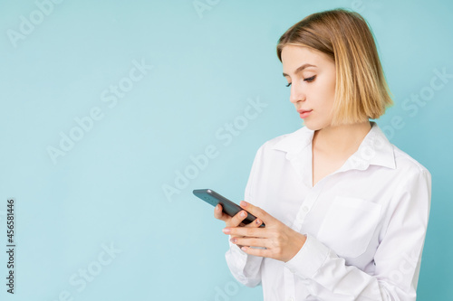 Digital lifestyle. Office woman. Mobile technology. Advertising background. Concentrated lady scrolling smartphone isolated blue copy space.