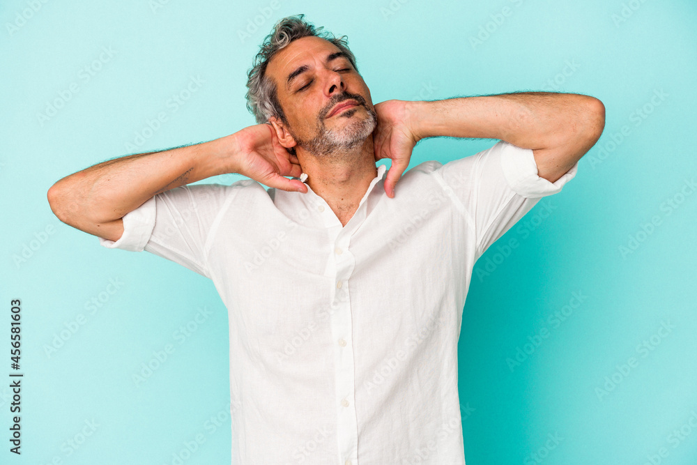 Middle age caucasian man isolated on blue background feeling confident, with hands behind the head. Middle age caucasian man isolated on blue background feeling confident, with hands behind the head.