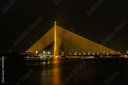 Rama VIII Bridge over Chao Phraya River,Bangkok, Thailand.Night city scene,modern architecture,long exposure lights. Travel transportation concept.