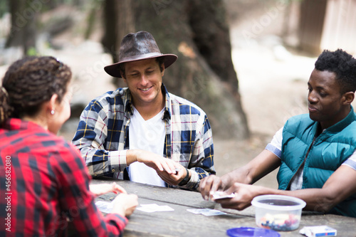 Three young adult hikers playing cards in forest  Arcadia  California  USA
