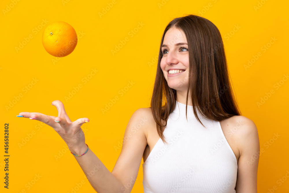 Young caucasian woman holding an orange isolated on orange background Young caucasian woman holding an orange isolated on orange background