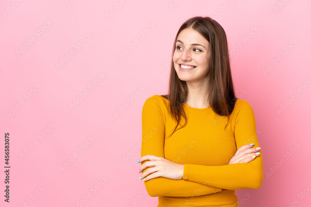 Fototapeta premium Young caucasian woman isolated on pink background looking to the side