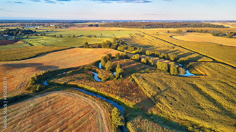 September agriculture fields aerial panorama. Sunny autumn landscape. Meadows, river, village