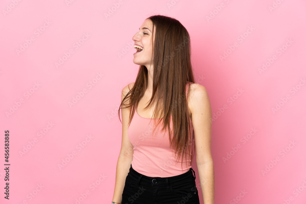 Young caucasian woman isolated on pink background laughing in lateral position Young caucasian woman isolated on pink background laughing in lateral position