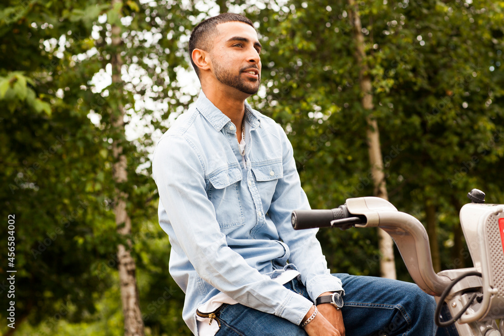 Obraz premium Young man on bicycle looking away