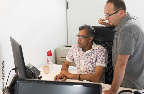 Colleagues in office looking at computer