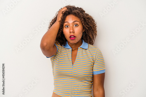 Young african american woman with curly hair isolated on white background being shocked, she has remembered important meeting. © Asier