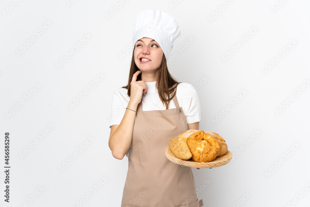 Young woman in chef uniform isolated on white background thinking an idea Young woman in chef uniform isolated on white background thinking an idea