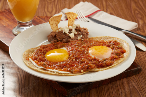 Huevos rancheros con salsa roja picante y tortilla de maiz + photo