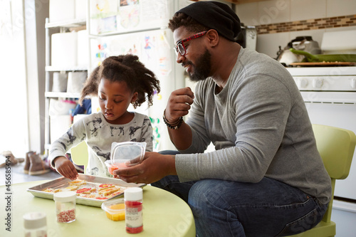 Фотография Father and daughter decorating unbaked cookies