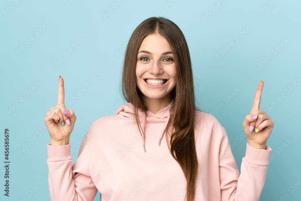 Young caucasian woman isolated on blue background pointing up a great idea Young caucasian woman isolated on blue background pointing up a great idea