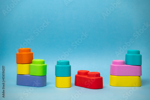 Colorful rubber toy blocks for babies, on blue background, copy space 