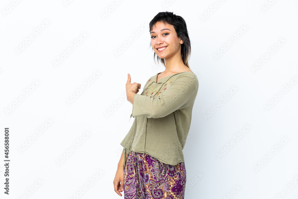 Young Uruguayan girl over isolated white background pointing back