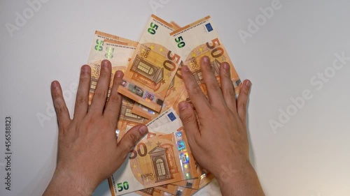 Static shot of a man's hands removing many 50 euro banknotes on a white background photo