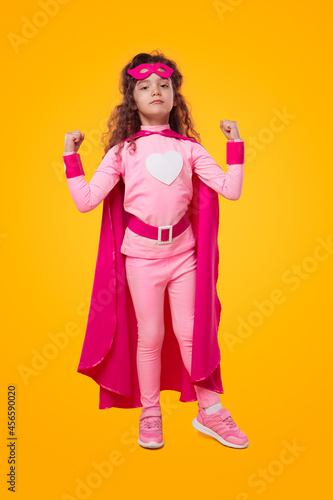 Strong superhero kid in pink outfit