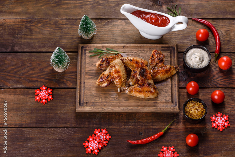 Grilled spicy chicken wings on a dark background with spices and herbs Grilled spicy chicken wings on a dark background with spices and herbs