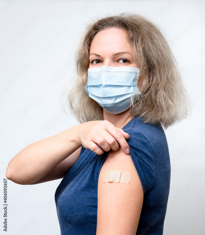 Vaccinated young woman showing shoulder after COVID-19 vaccine getting - obrazy, fototapety, plakaty 