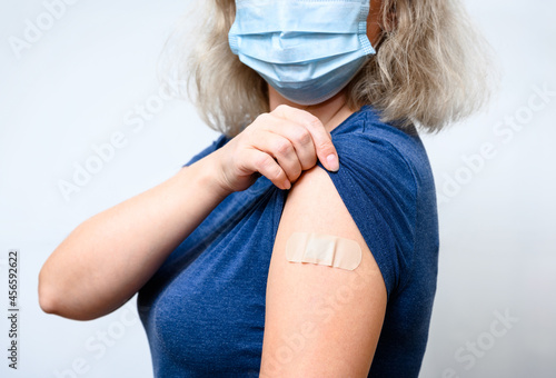 Vaccinated woman showing shoulder after COVID-19 vaccine getting photo