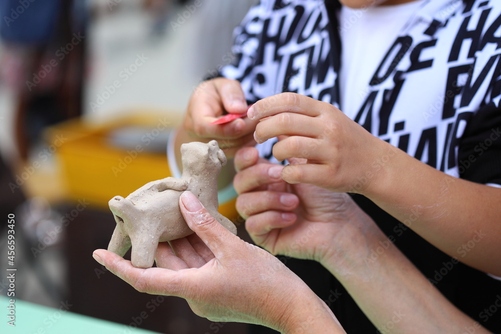 Master of ceramics teaches a student. the student sculpted a pottery. The master sculpts clay with his hands. Learning in the form of a game. Master of ceramics teaches a student. the student sculpted a pottery. The master sculpts clay with his hands. Learning in the form of a game.