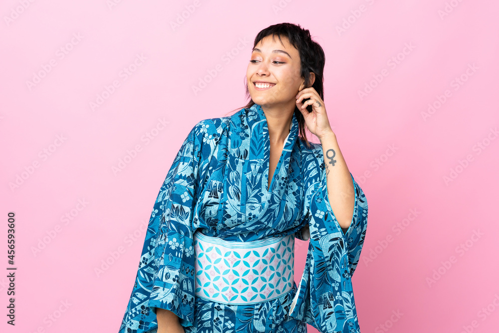Young woman wearing kimono over isolated blue background laughing Young woman wearing kimono over isolated blue background laughing