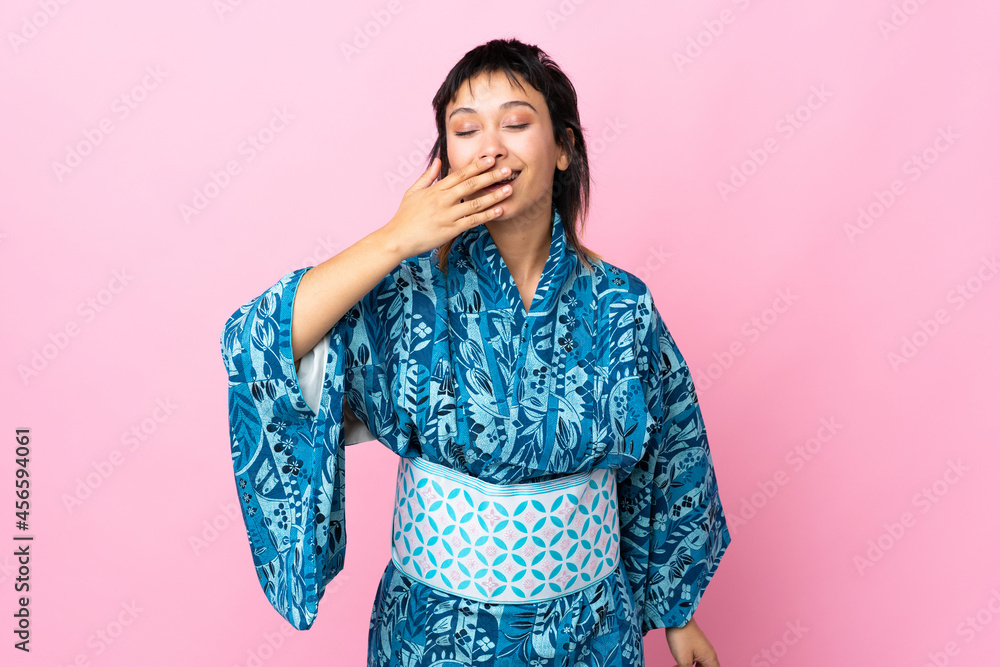 Young woman wearing kimono over isolated blue background happy and smiling covering mouth with hand Young woman wearing kimono over isolated blue background happy and smiling covering mouth with hand