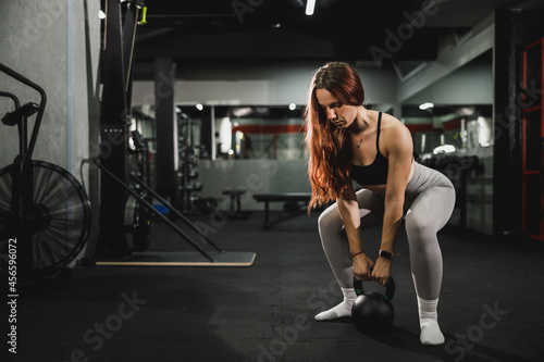 Fototapeta Naklejka Na Ścianę i Meble -  Muscular Woman Doing Training With Kettlebell At The Gym