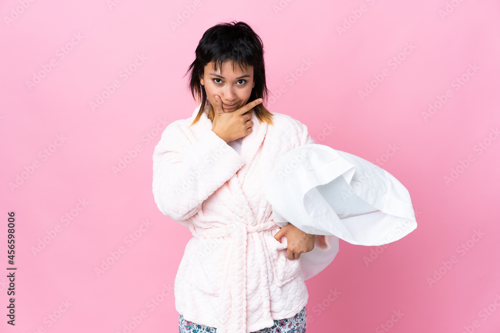 Young Uruguayan woman in pajamas over isolated pink background thinking an idea Young Uruguayan woman in pajamas over isolated pink background thinking an idea