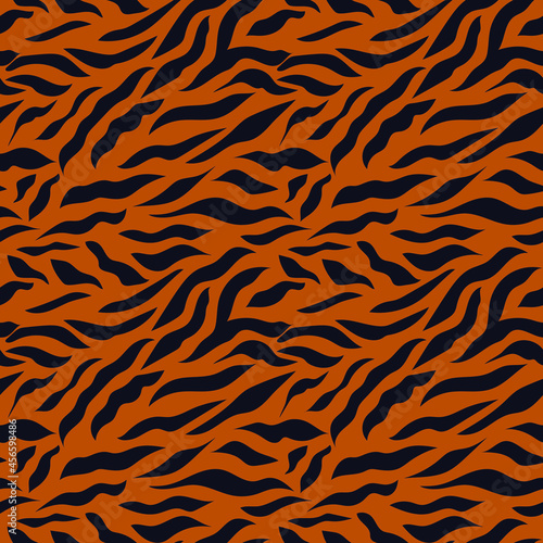 The tiger pattern is a symbol of 2022. Seamless pattern with black stripes on a brown background. Print for modern fabrics, throw pillows, wrapping paper. Vector.
