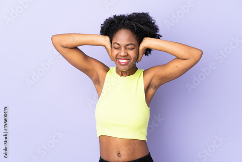 Young African American woman isolated on purple background frustrated and covering ears