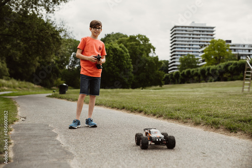teen boy with electric remote control car toy play outdoor on sidewalk and have fun while enjoy his childhood