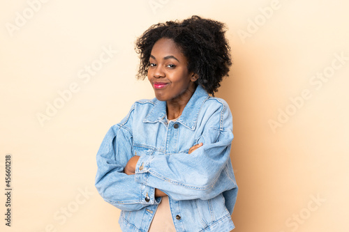 Young African American woman isolated on beige background making doubts gesture while lifting the shoulders