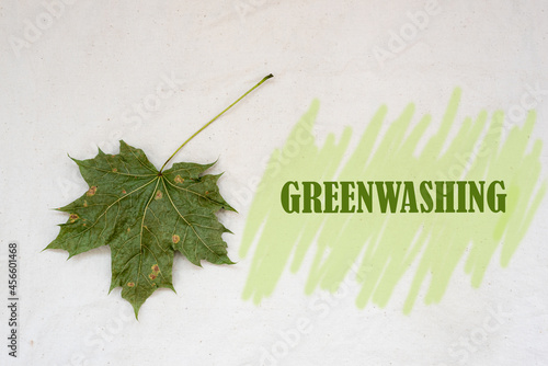 Greenwashing concept. Dry maple leaf and text with green marker strokes. Environmental marketing disinformation. photo