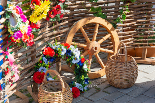 Wicker baskets and flowers on a wicker fence.